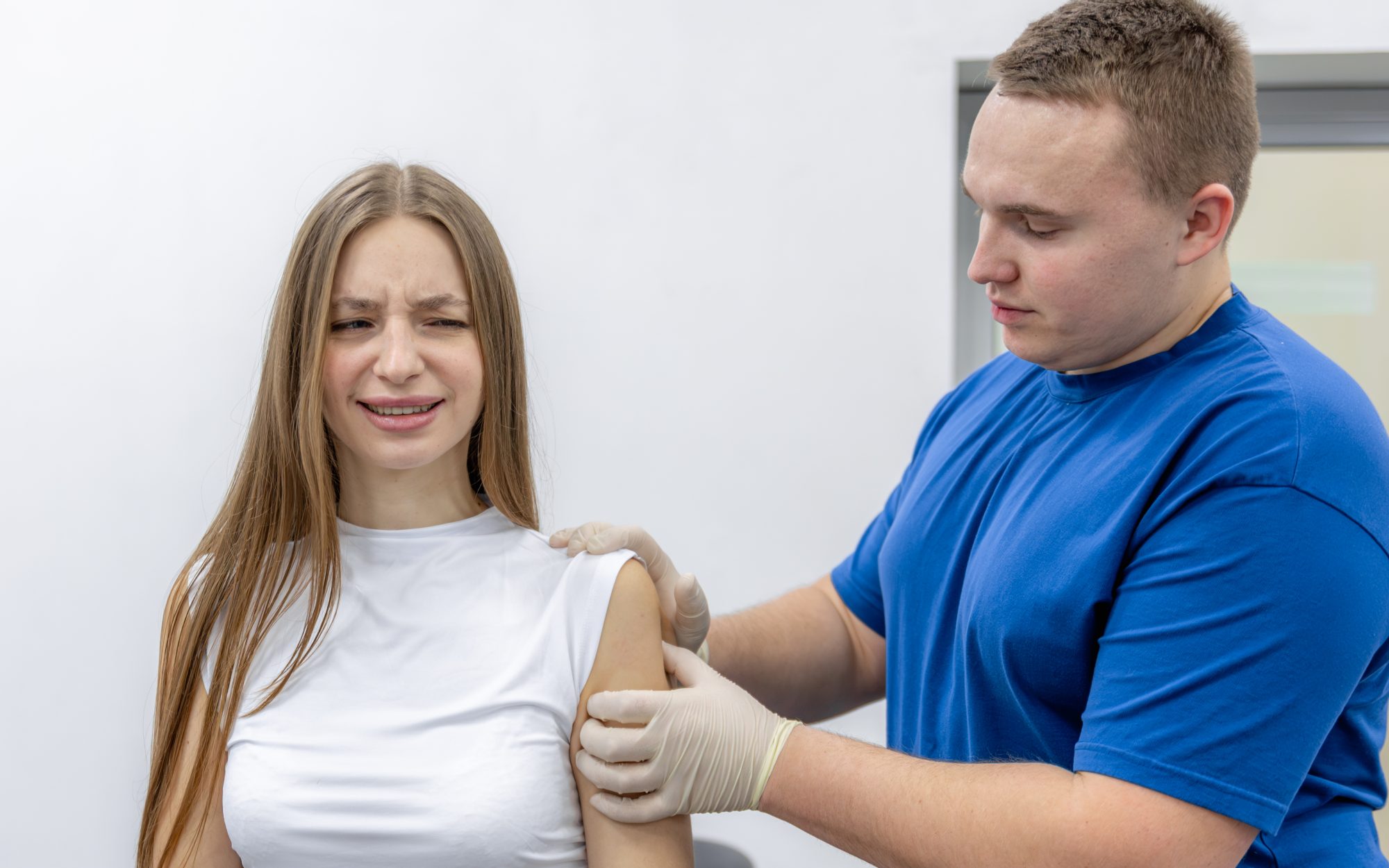 A clinician examining a patient's shoulder.