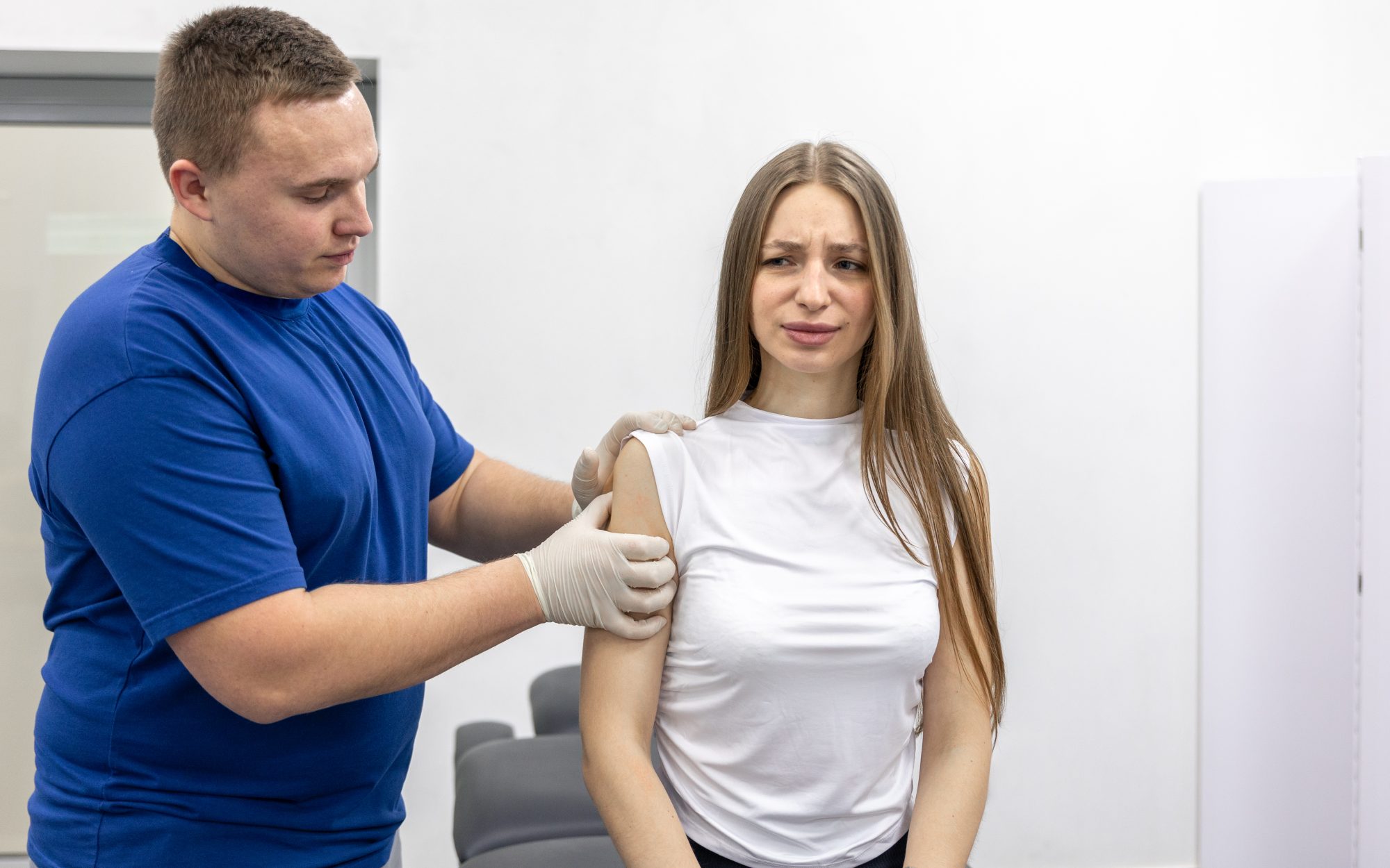 A physiotherapist assessing a patient's shoulder.